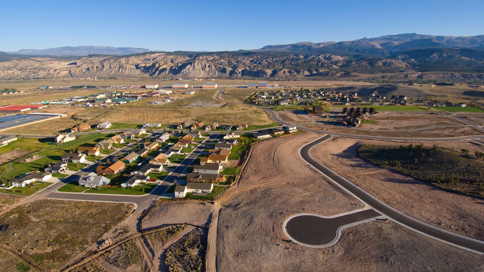 Suburban neighborhood with mountains and rocky landscape in background