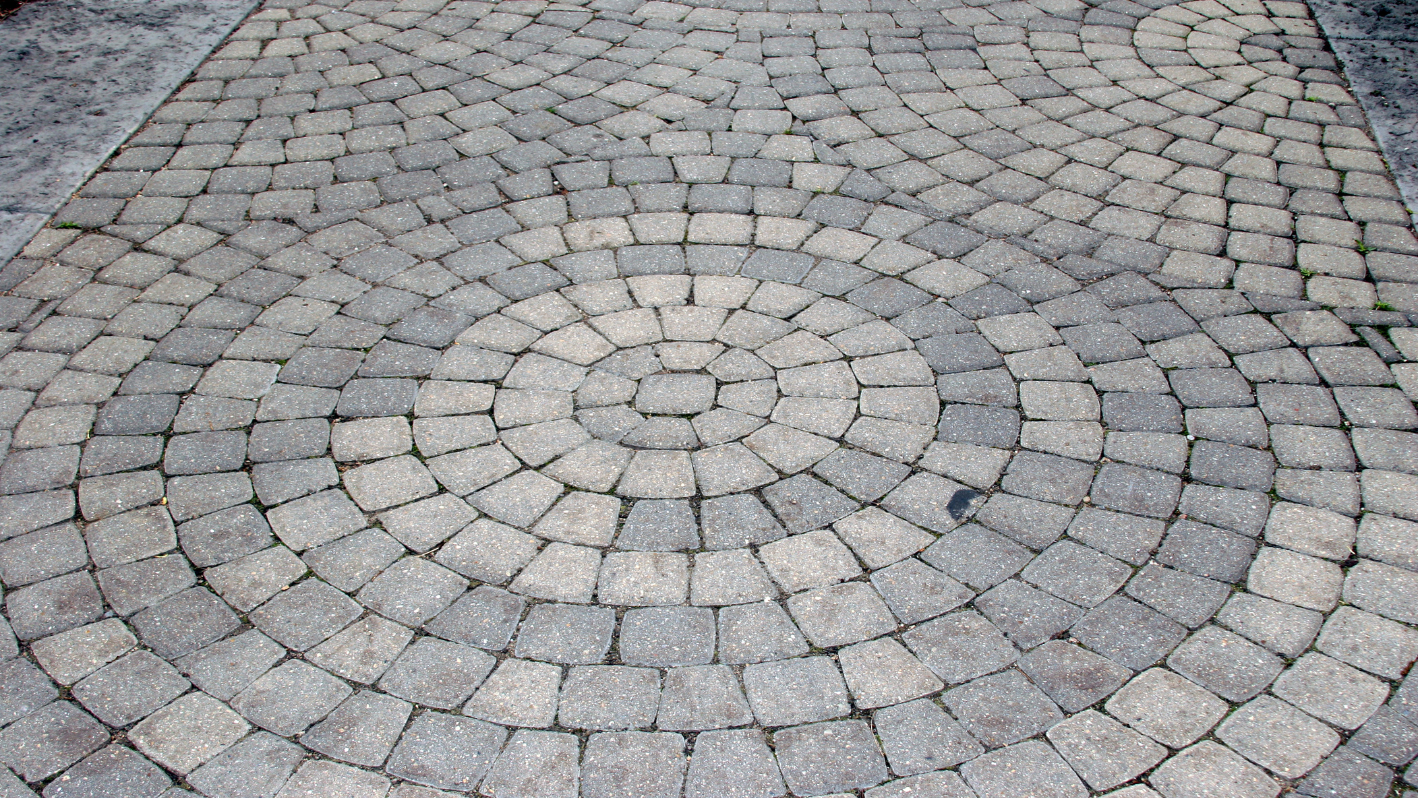 A close up of a brick sidewalk with a circular design