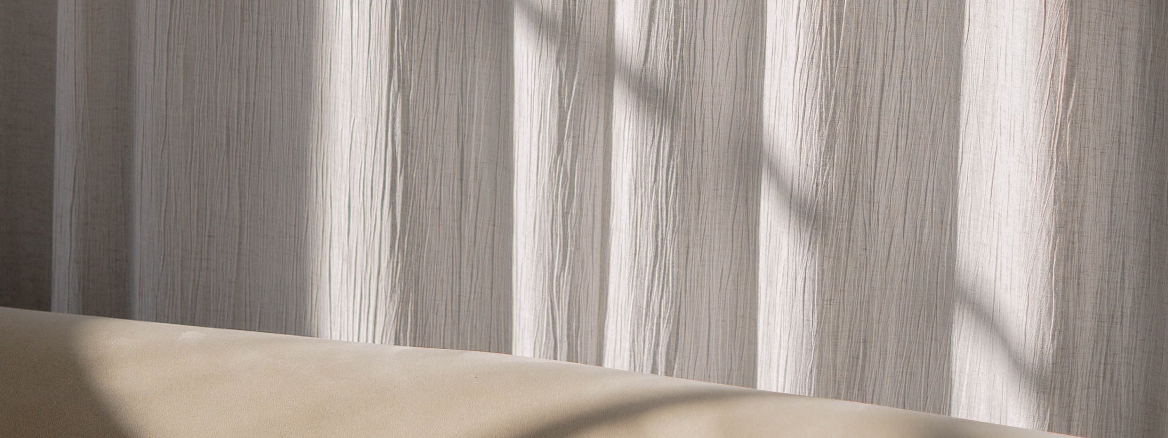 Soft light filtering through textured white curtains with shadows